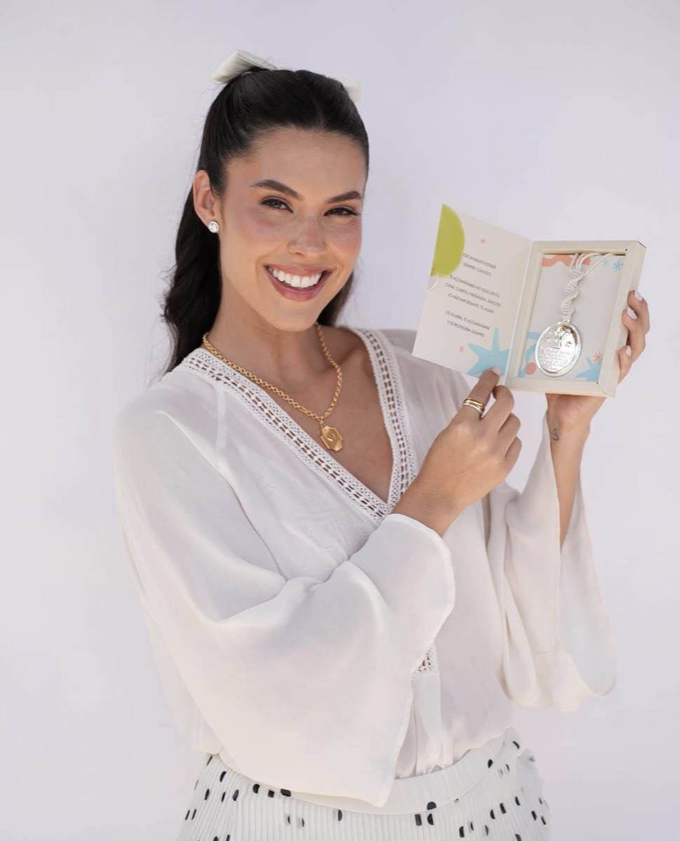 Mujer sonriendo con la caja abierta y la medalla