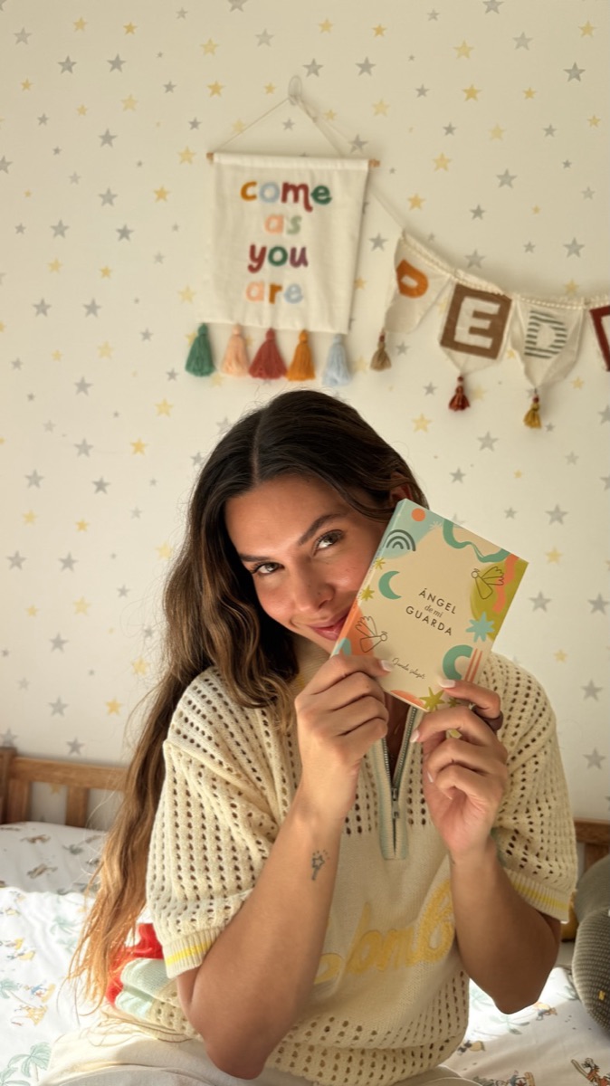 Mujer sosteniendo el angelito en el cuarto decorado para un bebé